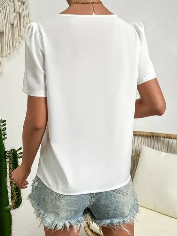 Blouse blanche femme à col asymétrique et manches bouffantes