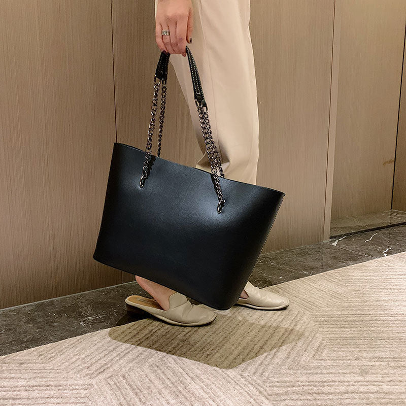 Sac à main noir femme en similicuir mat, porté épaule